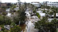 Foto udara memperlihatkan sebuah jalan yang tergenang air dan dipenuhi puing-puing setelah terjangan Badai Milton, di Siesta Key, Florida, pada tanggal 10 Oktober 2024. (CHANDAN KHANNA/AFP)