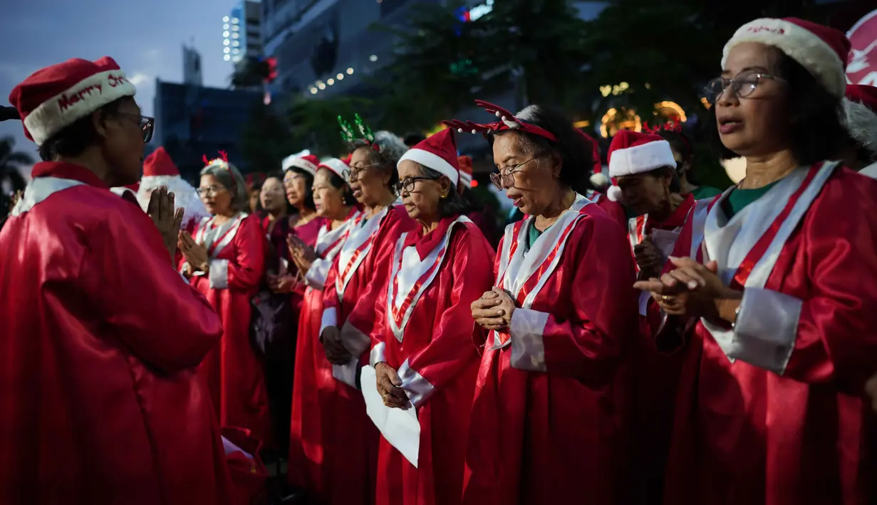 Mereka bersama-sama menyanyikan kidung serta lagu Natal secara massal bersama warga. Tampak dalam foto, Umat Kristiani berdoa bersama sebelum menyanyikan lagu-lagu Natal di Jakarta, Indonesia, Selasa, 23 Desember 2025. (AP Photo/Dita Alangkara)