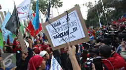 Buruh membawa spanduk saat berorasi di Tugu Proklamasi, Jakarta, Jumat (20/11). Dalam aksinya, para buruh menuntut pencabutan Peraturan Presiden (PP) No.78 Tahun 2015 tentang pengupahan, tolak formula upah minimum. (Liputan6.com/Immanuel Antonius)