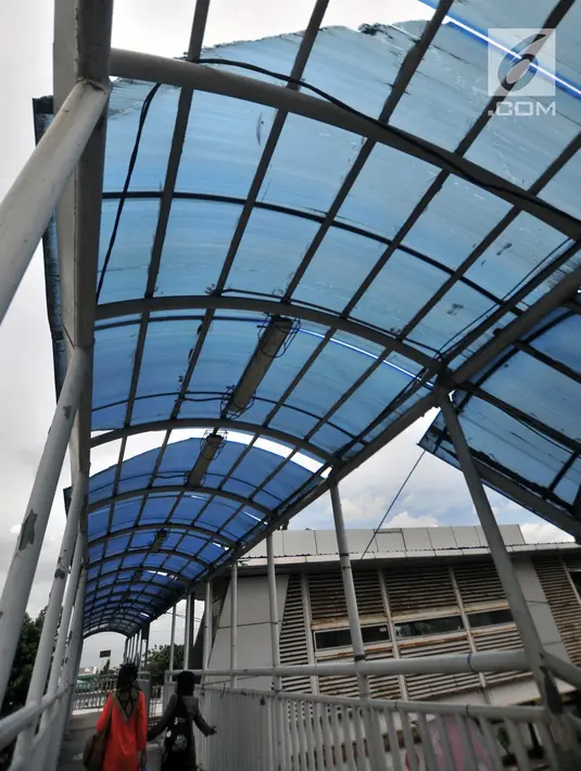 Pejalan kaki melintasi JPO di depan kantor Imigrasi Jakarta Timur, Kamis (17/1). JPO yang tidak terawat ini mengurangi keindahan serta mengganggu kenyamanan pejalan kaki yang melintas, terlebih saat hujan turun. (Merdeka.com/Iqbal S. Nugroho)