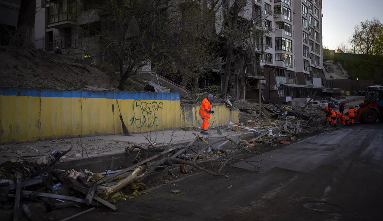 <p>Petugas kebersihan membersihkan lokasi ledakan di Kiev, Ukraina, Jumat (29/4/2022). Rusia menyerang Kiev tak lama setelah pertemuan antara Presiden Ukraina Volodymyr Zelenskyy dan Sekretaris Jenderal PBB António Guterres pada Kamis malam. (AP Photo/Emilio Morenatti)</p>