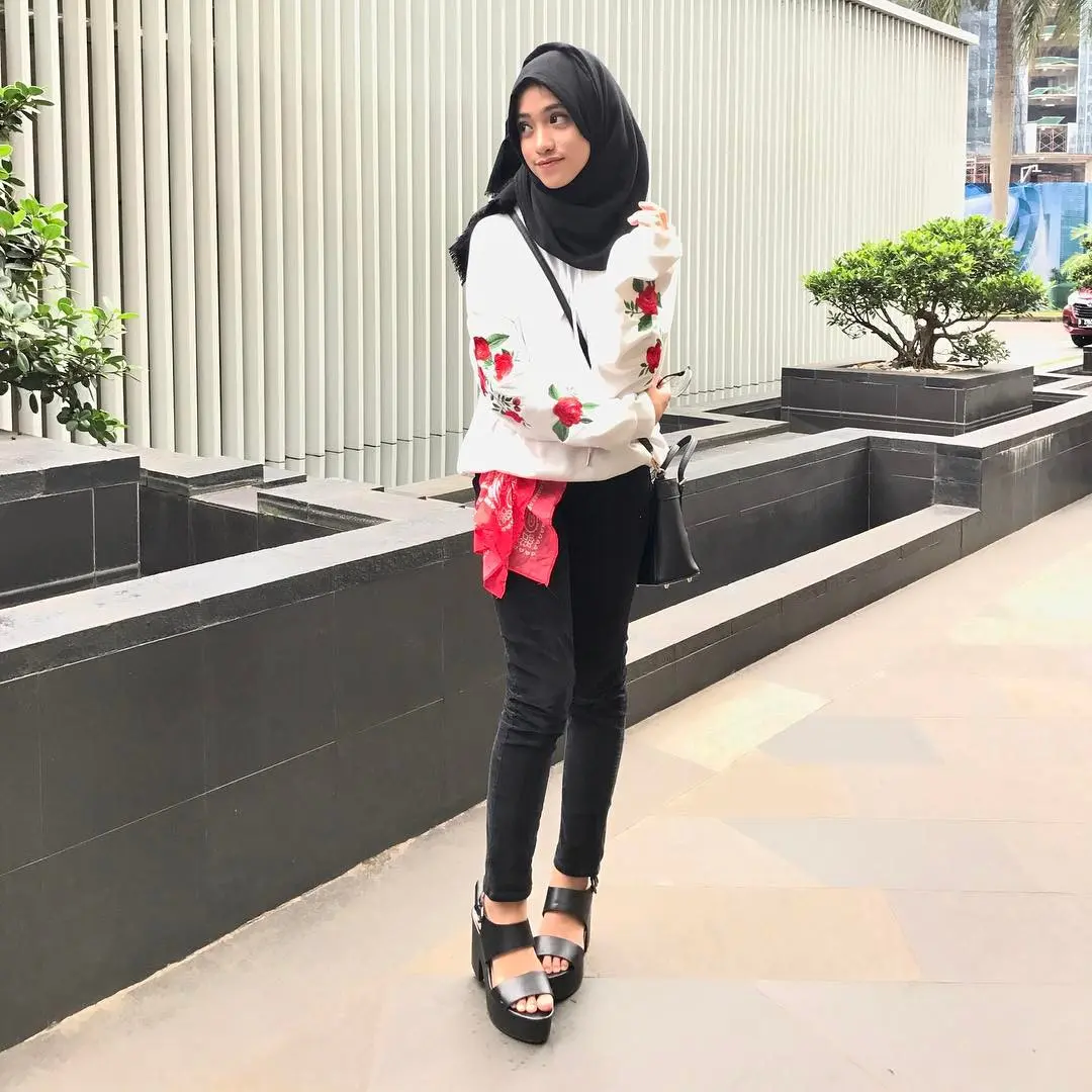 Pakai atasan dengan warna dasar putih yang diberi motif bunga warna merah dipadukan bersama celana hitam favoritmu, pilih platform sandals ya supaya makin kece. (sumber foto: @shireeenz/instagram)