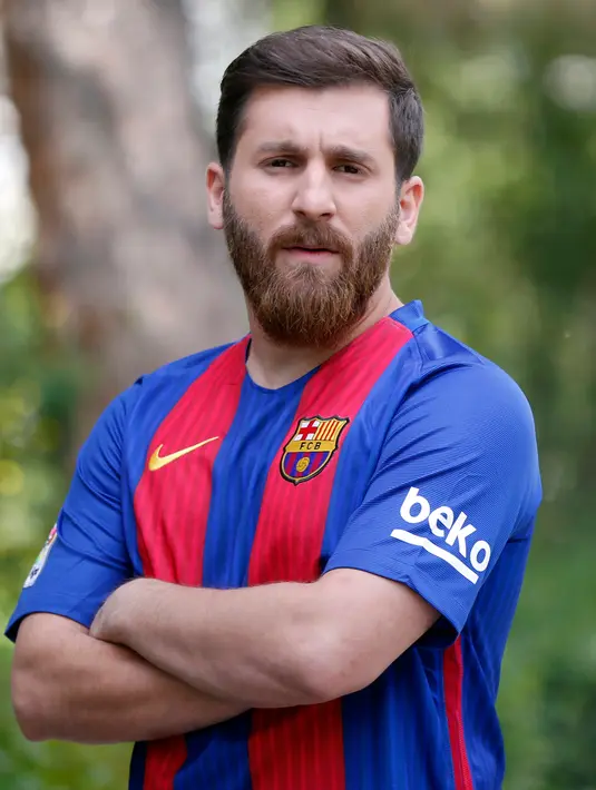 Pemuda asal Iran, Reza Parastesh yang berwajah mirip bintang Barcelona, Lionel Messi berpose di sebuah jalan di Teheran, Senin (8/5). Kini impian Reza adalah bertemu dengan idolanya di Barcelona dan jika bisa bekerja untuk sang bintang. (ATTA KENARE/AFP)