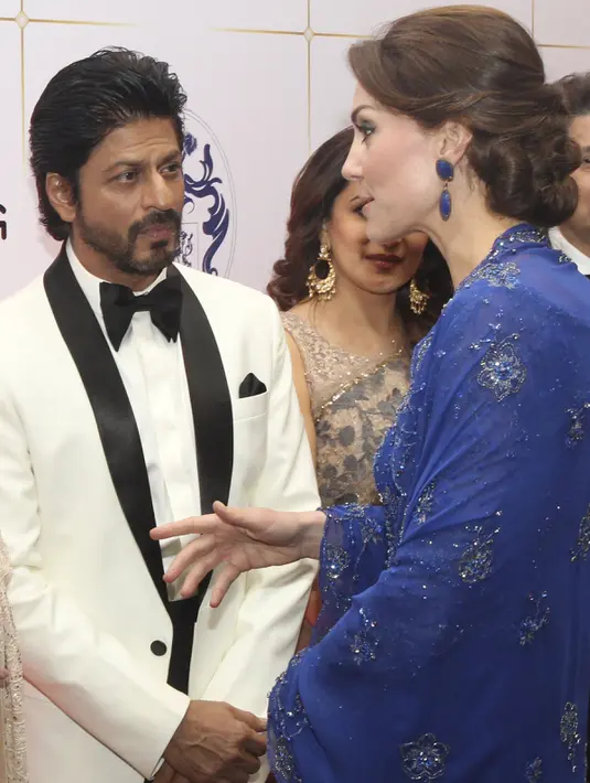 Kate Middleton berbincang dengan Shahrukh Khan saat menghadiri acara amal di Taj Palace Hotel, Mumbai, India, Minggu (10/4). Kate tampak mengenakan aksesoris anting rancangan desainer India dengan nilai sekitar Rp 46 juta. (REUTERS/Rafiq Maqbool/Pool)