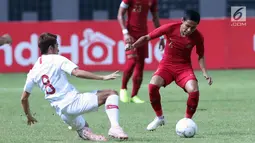 Pemain Timnas Indonesia, Evan Dimas Darmono (kanan) berebut bola dengan pemain Hong Kong pada laga uji coba internasional di Stadion Wibawa Mukti, Cikarang, Selasa (16/10). Babak pertama, Indonesia unggul 1-0. (Liputan6.com/Helmi Fithriansyah)
