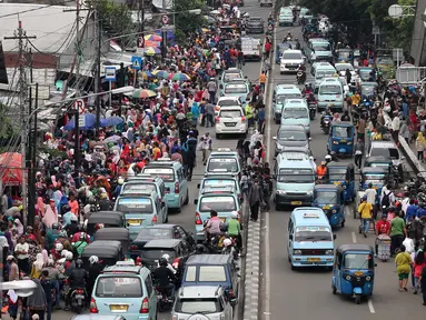 Suasana kemacetan lalu lintas di kawasan Tanah Abang, Jakarta, Senin (27/6). H-9 menjelang Idul Fitri 1437 H, Pusat perbelanjaan Tanah Abang semakin dipadati pengunjung yang ingin membeli kebutuhan lebaran terutama pakaian. (Liputan6.com/Gempur M Surya)