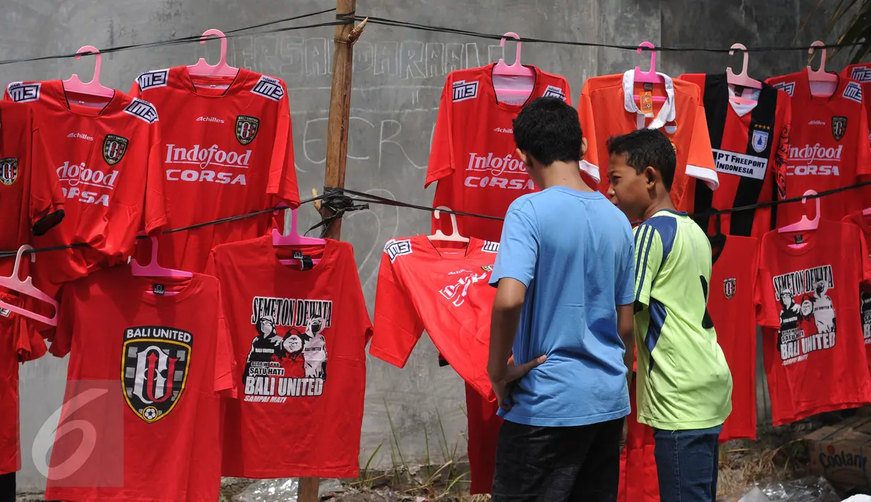 Beberapa suporter memilih kaos tim yang dijajakan di luar Stadion Dipta, Gianyar, Bali, Minggu (30/8/2015). Jelang pembukaan turnamen Piala Presiden 2015, Stadion Kapten I Wayan Dipta dijaga ratusan personel keamanan. (Liputan6.com/Helmi Fithriansyah)
