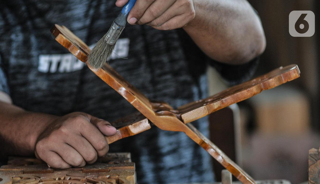 Pekerja menyelesaikan pembuatan rehal atau meja untuk Al-qur’an di Toko Mabruri 12, Klender, Jakarta, Rabu (13/4/2022). Penjualan rehal pada Ramadhan kali ini mengalami peningkatan hingga 50 persen dibandingkan tahun sebelumnya. (merdeka.com/Iqbal S Nugroho)