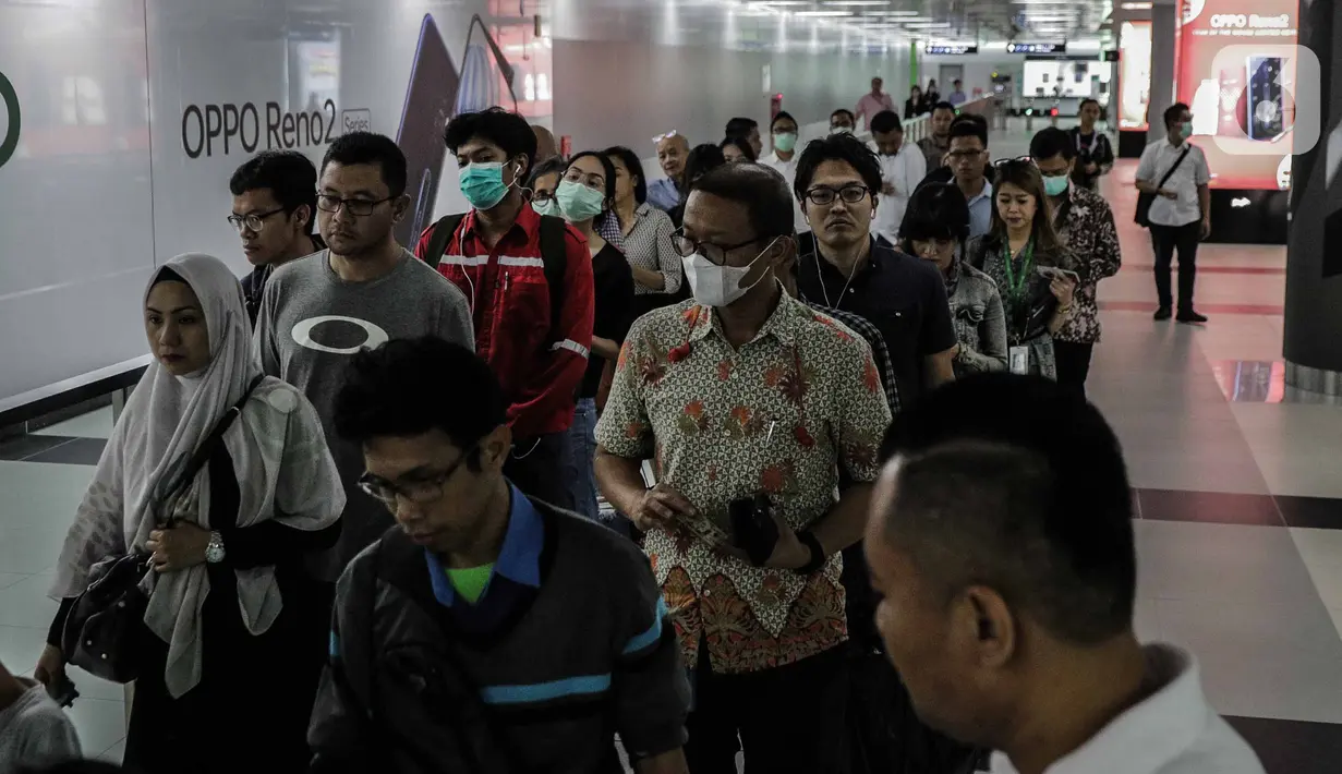 Penumpang menggunakan masker saat antre memasuki kereta Mass Rapid Transit (MRT) di Stasiun Bundaran HI Jakarta, Selasa (3/3/2020). Penumpang dengan gejala demam tinggi dilarang masuk dan menggunakan MRT sebagai upaya pencegahan penyebaran virus corona Covid 19. (Liputan6.com/Faizal Fanani)