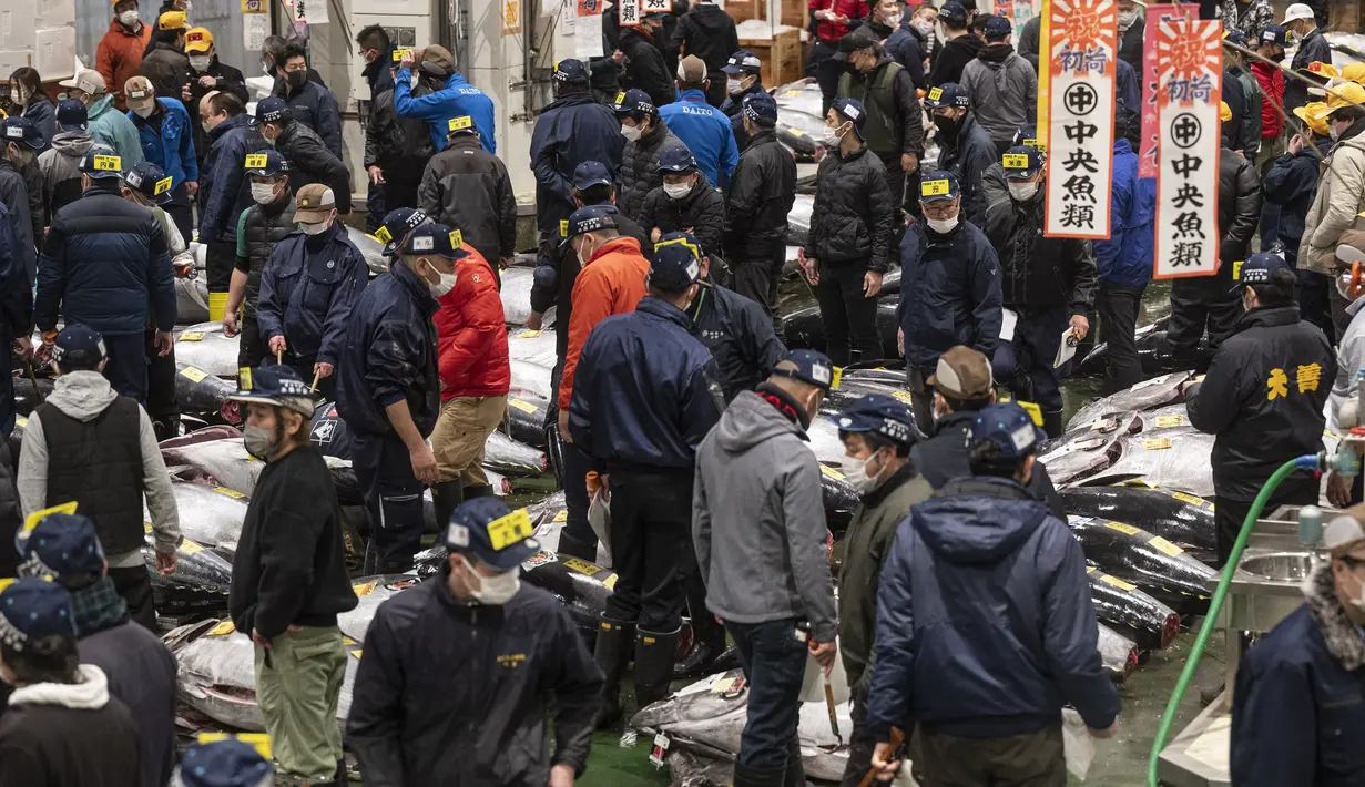Penjual dan pembeli grosir menghadiri lelang tuna pertama Tahun Baru di pasar ikan Toyosu di Tokyo (5/1/2023). Pada tahun ini, lelang tuna tertinggi terjual lebih dari USD 270.000. Hampir dua kali lipat dari harga tahun lalu. (AFP/Richard A. Brooks)