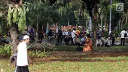 Salah satu peserta aksi membaca Al-Quran di taman pembatas Jalan Medan Merdeka Barat, Jakarta, Jumat (14/6/2019). Massa berkumpul menyampaikan pendapat terkait sidang perselisihan hasil pilpres 2019. (Liputan6.com/Helmi Fithriansyah)