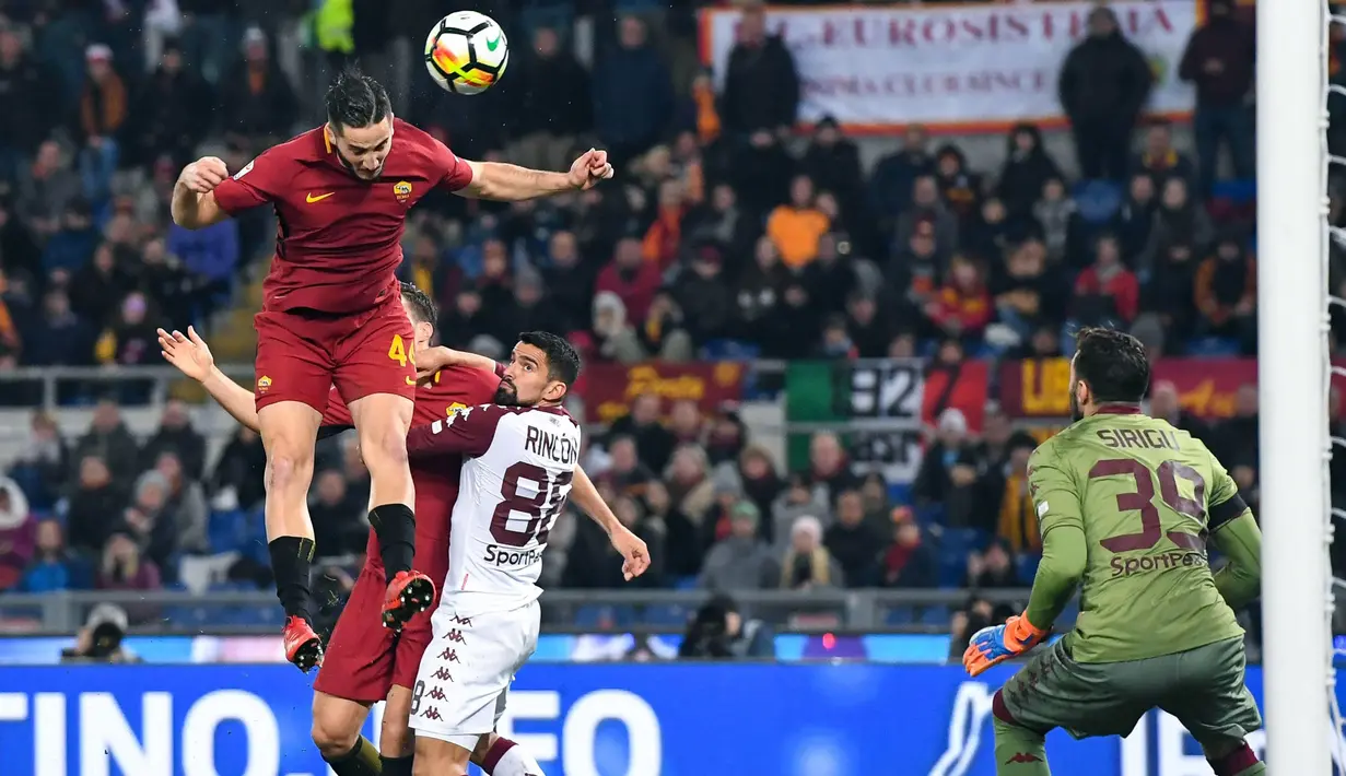 Aksi pemain AS Roma, Kostas Manolas (kiri) menyundul bola ke gawang Torino pada laga Serie A antara Roma vs Torino di Olympic Stadium, Roma, (9/3/2018). Roma menang 3-0. (Alessandro Di Meo/ANSA via AP)