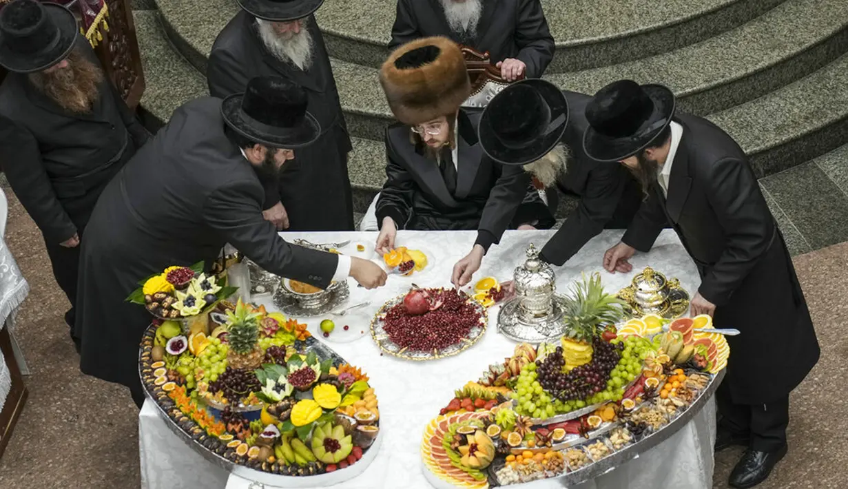 Umat Yahudi ultra-ortodoks dari dinasti Sadigura Hasidic merayakan Hari Raya Tu Bishvat atau Tahun Baru Pohon di Bnei Brak, Israel, 16 Januari 2022. Pada perayaan ini mereka duduk bersama para rabi di sekitar meja panjang dengan hidangan aneka jenis buah-buahan. (AP Photo/Ariel Schalit)