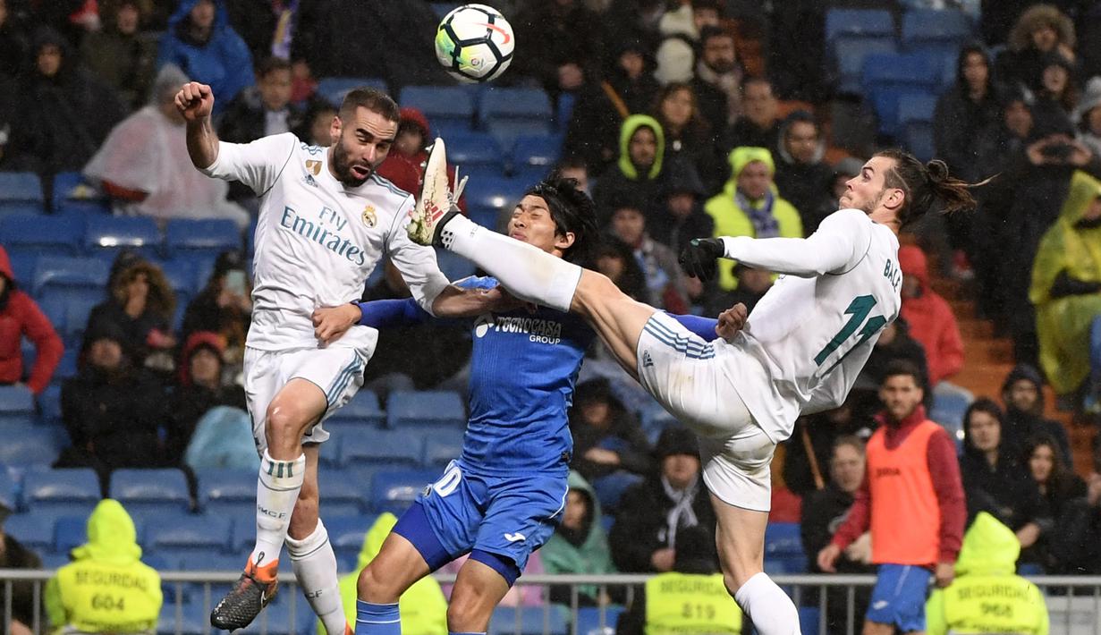 Gareth Bale (kanan) dan rekannya Dani Carvajal (kiri) menghalau bola dari kejaran pemain Getafe, Gaku Shibasaki pada lanjutan La Liga Santander di Santiago Bernabeu stadium, Madrid, (3/3/2018). Real madrid menang 3-1. (AFP/Pierre-Philippe Marcou)