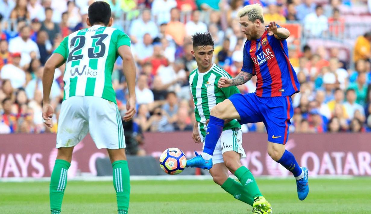 Pemain Barcelona, Lionel Messi, berusaha melewati hadangan pemain Real Betis dalam laga La Liga di Stadion Camp Nou, Minggu (21/8/2016) dini hari WIB. (AFP/Pau Barrena)