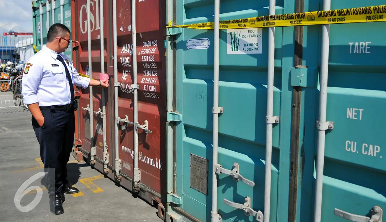 Petugas mengamati kontainer berisi pupuk ilegal yang telah disegel di Pelabuhan Tanjung Priok, Jakarta, Kamis (7/4). Sebanyak 6 kontainer pupuk ilegal berhasil diamankan pihak berwajib. (Liputan6.com/Yoppy Renato)