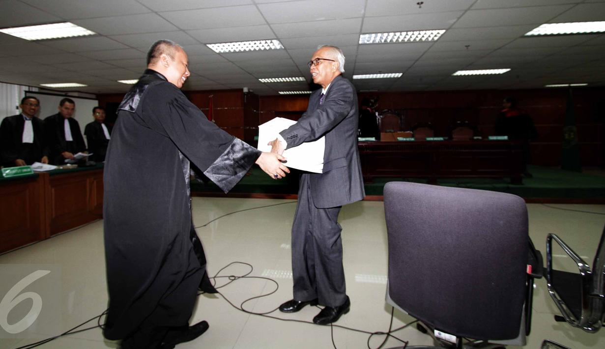 Terdakwa kasus suap hakim PTUN Medan, OC Kaligis dibantu petugas membawa berkas saat sidang pembacaan dakwaan di Pengadilan Tipikor, Jakarta, Kamis (27/8/2015). Majelis hakim kembali menunda sidang hingga 31 Agustus mendatang. (Liputan6.com/Helmi Afandi)