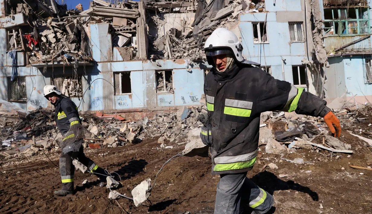 Tim penyelamat Ukraina memindahkan puing-puing dari bangunan tempat tinggal berlantai lima yang hancur setelah serangan rudal di tengah invasi Rusia ke Ukraina di Zaporizhzhia pada 2 Maret 2023. Serangan Rusia di sebuah blok apartemen di kota Zaporizhzhia, Ukraina selatan telah menewaskan sedikitnya tiga orang, kata pihak berwenang setempat pada 2 Maret, saat operasi pencarian sedang berlangsung. (AFP/Katerina Klochko)