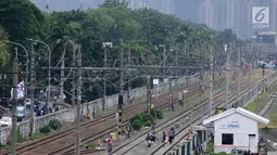 Aktivitas pekerja di jalur dwiganda atau double-double track (DDT) kawasan Jatinegara, Jakarta, Jumat (12/4). DDT Jatinegara-Cakung memiliki panjang 9,5 kilometer dari panjang lintas DDT Manggarai-Cikarang yakni 35 Km. (Liputan6.com/Herman Zakharia)