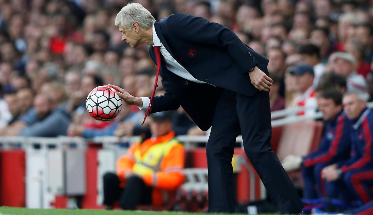 Pelatih Arsenal Arsene Wenger memungut bola pada Laga lanjutan Liga Premier Inggris di Emirates Stadium. Minggu (04/10/2015). Arsenal menang 3-0 atas MU. (Action Images via Reuters / Carl Recine Livepic)