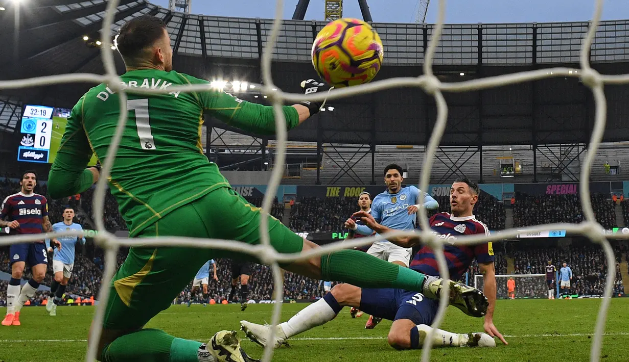 Pemain Manchester City, Omar Marmoush mencetak gol ke gawang Newcastle yang dijaga Martin Dubravka dalam laga lanjutan Liga Inggris 2024/2025 di Etihad Stadium, Manchester, Inggris, Sabtu (15/02/2025) waktu setempat. (AFP/Oli Scarff)