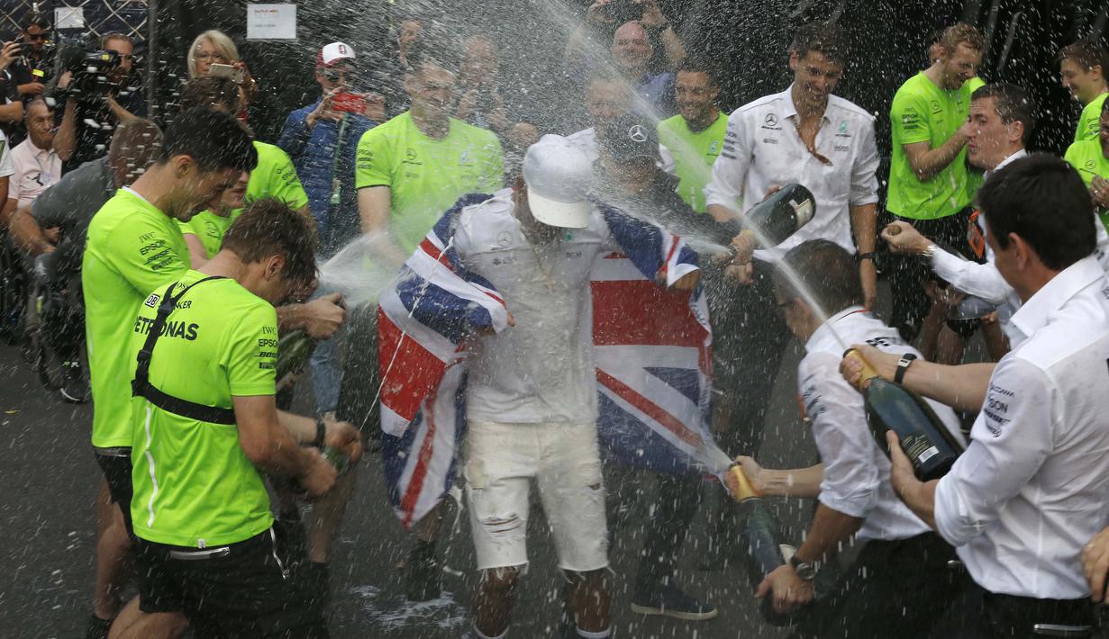 Lewis Hamilton merayakan keberhasilan meraih gelar F1 2017 bersama crew Mercedes di pit lane pada balapan di Hermanos Rodriguez racetrack, Mexico City, (29/10/20170). Hamilton finis kedelapan pada balapan tersebut. (AP/Marco Ugarte)