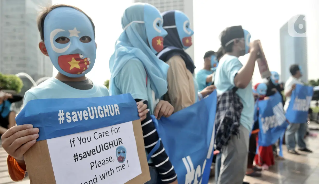 Warga mengenakan topeng bendera Turkestan Timur dan membentangkan poster saat menggelar Aksi Save Uighur selama Hari Bebas Kendaraan Bermotor (HBKB) atau Car Free Day (CFD), Jakarta, Minggu (22/12/2019). (merdeka.com/Iqbal S. Nugroho)
