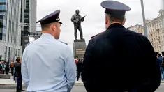 Petugas polisi berjaga-jaga saat upacara peresmian patung Mikhail Kalashnikov di pusat kota Moskow, Rusia (19/9). Mikhail Kalashnikov merupakan penemu senapan serbu AK-47. (AFP Photo/Maxim Zmeyev)