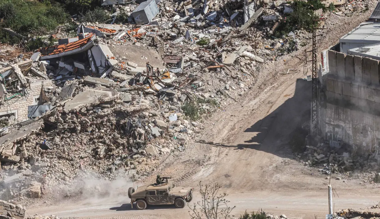 Foto menunjukkan sebuah kendaraan militer Israel melaju di antara rumah-rumah yang hancur di Lebanon Selatan, pada Senin 27 April 2026. (Jalaa MAREY/AFP)
