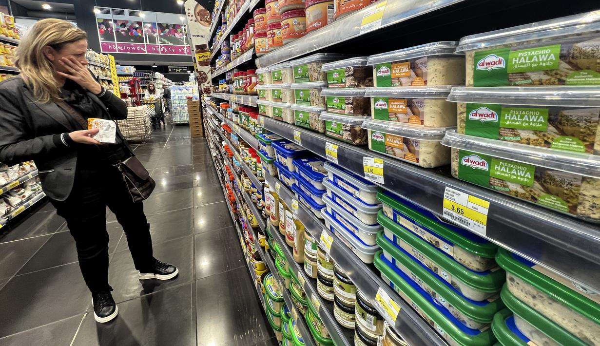 Seorang perempuan berbelanja di supermarket di mana barang dihargai dalam dolar, di Beirut, Lebanon, Rabu (1/3/2023). Langkah baru akan berlaku untuk impor yang dibeli dalam dolar oleh pemasok. Namun barang yang dibeli menggunakan mata uang nasional, seperti rokok, roti, buah, dan sayuran akan tetap dipajang dalam pound. (AP Photo/Hussein Malla)