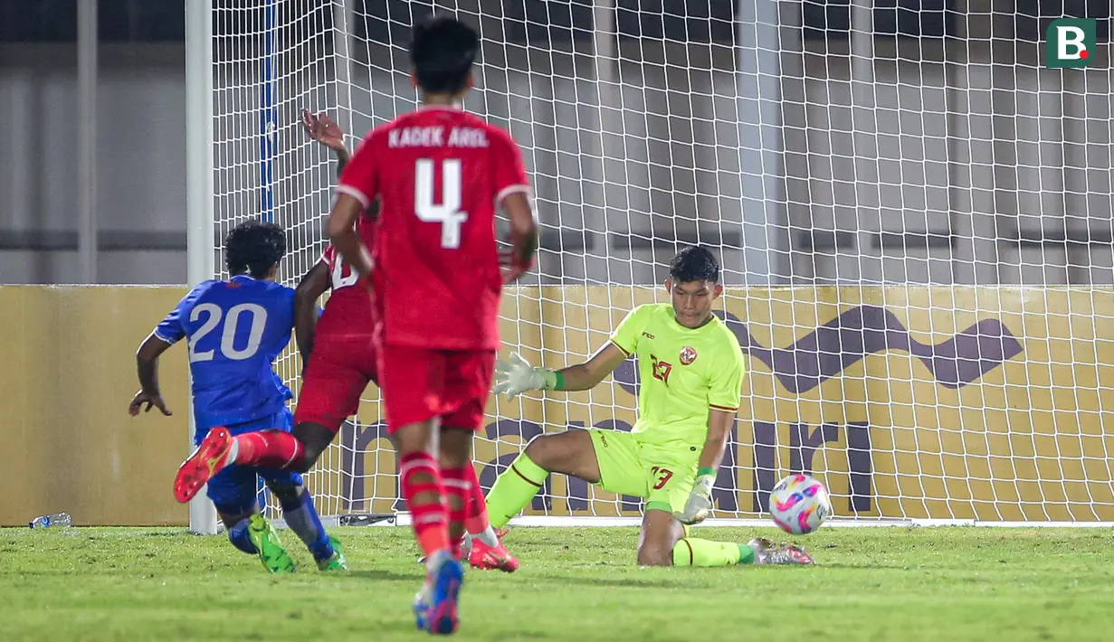 Kiper Timnas Indonesia, Ikram Al Giffari menghalau tendangan pemain Maladewa, Muzdhan Hassan (kiri) pada laga Grup F Kualifikasi Piala Asia U-20 2024 di Stadion Madya, Senayan, Jakarta, Rabu (25/09/2024). (Bola.com/Bagaskara Lazuardi)