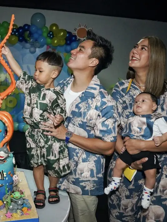 Paula mengenakan one set terdiri dari atasan kemeja dan midi skrit, serasi dengan Baim yang menggunakan kemeja dengan desain Gajah. Begitu kedua anaknya, sama-sama mengggunakan pakaian serupa. @baimwong