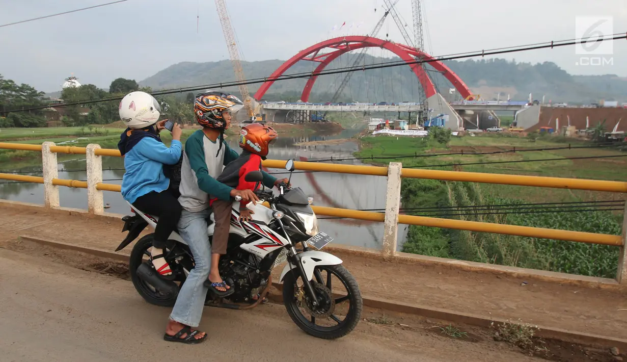 Warga menonton kendaraan pemudik yang melintasi Jembatan Kali Kuto pada ruas tol fungsional Batang - Semarang, Gringsing, Jateng, Rabu (13/6). Berfungsinya Jembatan ini akan memperlancar arus mudik dan arus balik Lebaran 2018. (Liputan6.com/Arya Manggala)
