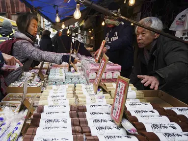 Warga membeli bahan-bahan untuk membuat makanan tahun baru atau osechi di Pasar Tsukiji, Tokyo, Jepang, Kamis (26/12/2019). Osechi terdiri dari berbagai jenis makanan istimewa. (AP Photo/Eugene Hoshiko)