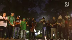 Gabungan suporter klub sepak bola bernyanyi dalam aksi solidaritas terkait tragedi teror bom di Surabaya dan Sidoarjo di Taman Suropati, Jakarta, Senin (14/5). Para suporter mengutuk teror yang terjadi di Indonesia. (Liputan6.com/Immanuel Antonius)