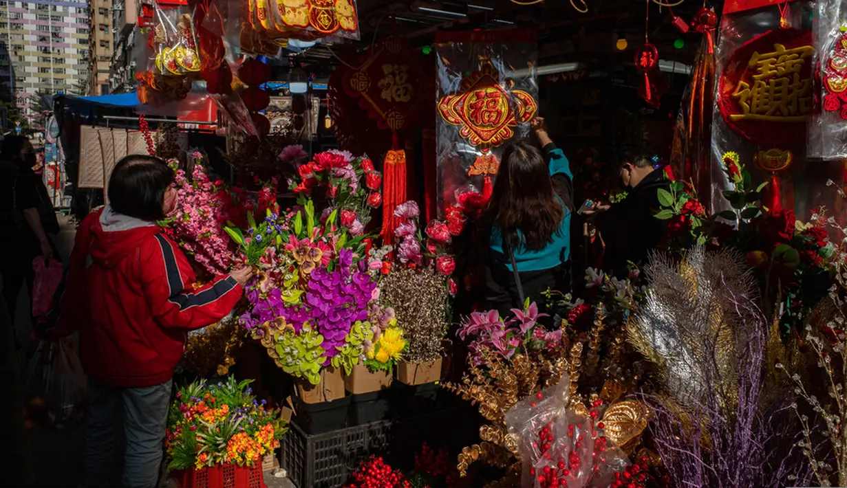 Para pembeli melihat dekorasi Tahun Baru Imlek yang dijual di sebuah kios pinggir jalan di Distrik Sham Shui Po, Hong Kong, 18 Januari 2023. Tahun Baru Imlek 2023 yang disebut Tahun Kelinci akan jatuh pada tanggal 22 Januari. (AP Photo/Anthony Kwan)