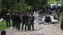 Sejumlah personel militer berkumpul di lokasi ledakan sebuah bom yang disembunyikan di bawah tanah di provinsi Yala, selatan Thailand, Jumat (23/9). Setelah meledakkan bom dari jarak jauh, pelaku menembaki polisi dari balik pepohonan. (KATAWUT CHUM/AFP)