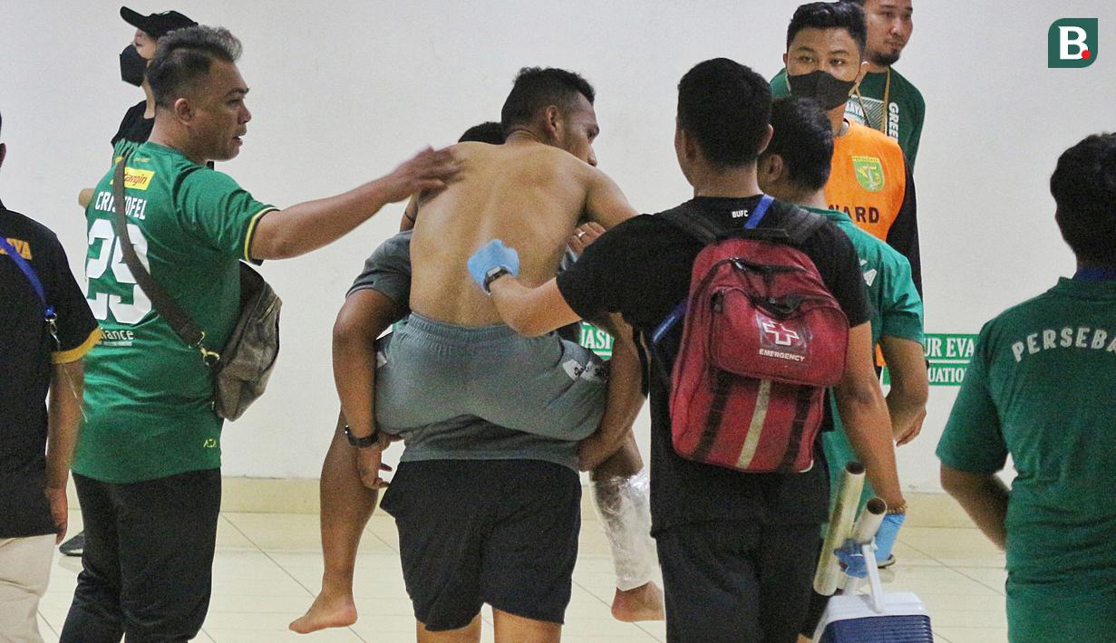 Bahkan Irfan Jaya sampai harus digendong ofisial Bali United untuk kembali ke kamar ganti. Ini merupakan langkah antisipasi agar cederanya tak semakin fatal. (Bola.com/Wahyu Pratama)