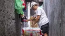 Seorang pria menyiapkan sampah anorganik rumah tangga (dalam bentuk karton dan botol plastik) untuk disimpan di bank sampah setempat, Jakarta, Kamis 4 Juni 2026, sebagai bagian dari instruksi Pemprov DKI yang mewajibkan warga memilih dan memilah sampah untuk mengurangi beban sampah yang semakin menumpuk di ibu kota. (BAY ISMOYO/AFP)