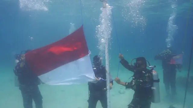 Kibar bendera di bawah laut Pulau Pahawang, Lampung.