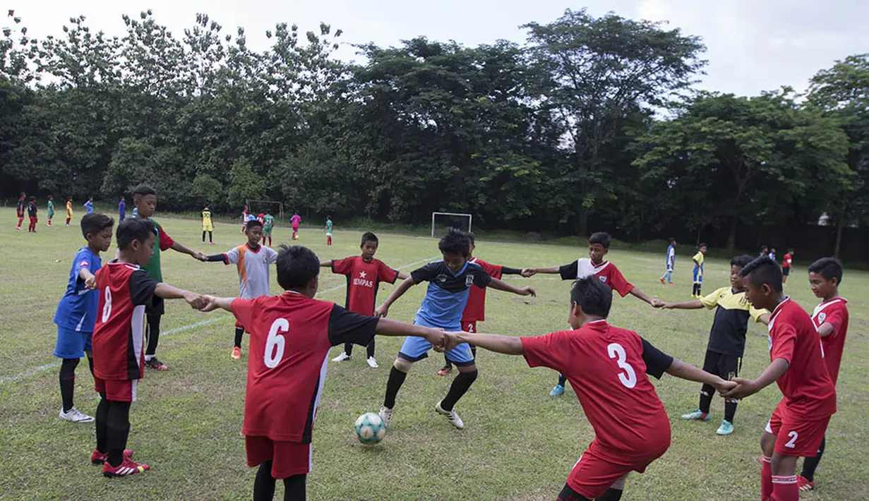 Para pesepak bola muda Tangerang melakukan pemanasan sebelum bertanding untuk menarik perhatian pelatih Bali United, Indra Sjafri, di Lapangan MAN Insan Cendikia, Tangerang, Jumat (8/1/2016). (Bola.com/Vitalis Yogi Trisna)