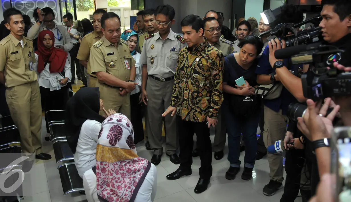 MenPANRB Yuddy Chrisnandi berbincang dengan pengunjung saat melakukan Inspeksi Mendadak (sidak) di Pertanahan Jakarta Timur, Senin (11/7). Menpan RB juga melakukan sidak ke tempat-tempat pelayanan publik. (Liputan6.com/Johan Tallo)