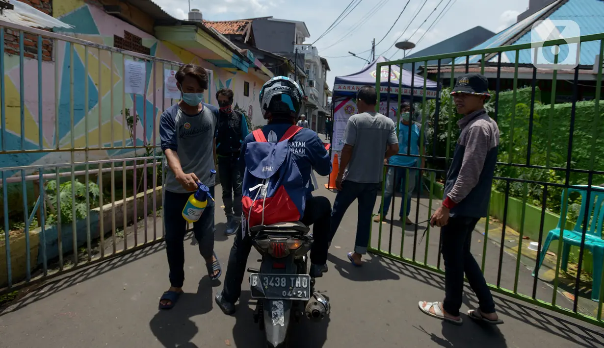 Anggota Karang Taruna menyemprotkan cairan disinfektan ke kendaraan yang memasuki pemukiman di Kelurahan Kebon Sirih, Jakarta, Rabu (1/4/2020). Warga di kelurahan itu memberlakukan akses satu pintu masuk dan menyemprotkan disinfektan guna mencegah penyebaran virus COVID-19. (merdeka.com/Imam Buhori)