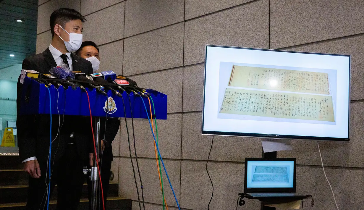Polisi menunjukkan gambar gulungan kaligrafi karya Mao Zedong, yang telah ditemukan, pada konferensi pers di Hong Kong, 7 Oktober 2020. Gulungan sepanjang 2,8 meter itu ditemukan dalam keadaan terpotong menjadi dua bagian karena dianggap terlalu panjang untuk dipajang.    (ISAAC LAWRENCE/AFP)