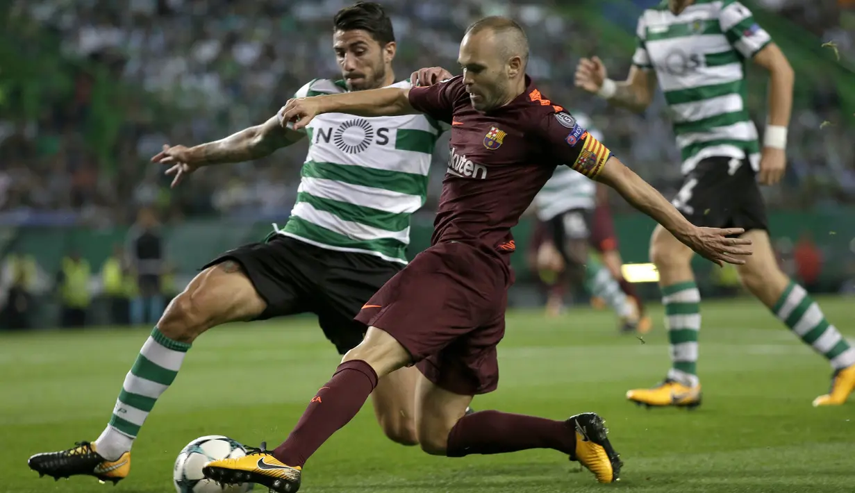 Gelandang Barcelona, Andres Iniesta, berusaha melewati bek Sporting Lisbon, Cristiano Piccini, pada laga Liga Champions di Stadion Alvalade, Lisbon, Rabu (27/9/2017). Sporting kalah 0-1 dari Barcelona. (AFP/Armando Franca)