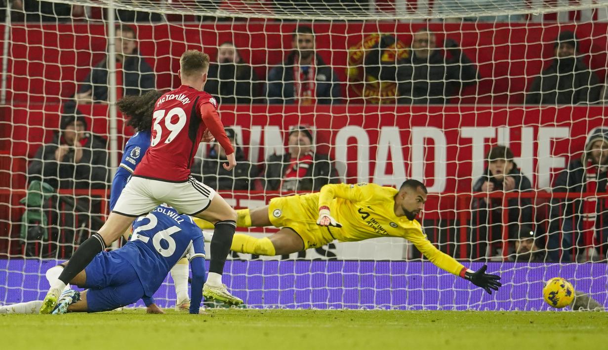 Kiper Chelsea, Robert Sanchez (kanan), tidak dapat menjangkau bola dari tendangan pemain Manchester United, Scott McTominay (kiri),  dalam pertandingan pekan ke-15 Liga Inggris 2023/2024 yang berlangsung di Old Trafford, Kamis (7/12/2023) dini hari WIB. (AP Photo/Dave Thompson)