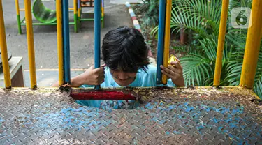 Seorang anak bermain dengan kondisi fasilitas yang rusak di Ruang Publik Terpadu Ramah Anak (RPTRA) Amir Hamzah, Jakarta, Rabu (12/7/2023). RPTRA Amir Hamzah terpantau tak terawat dengan wahana bermain yang rusak dan besi-besi berkarat. (Liputan6.com/Faizal Fanani)