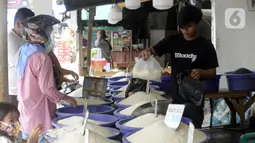 Pedagang beras melayani pembeli di pinggir Jalan Raya Pamulang, Tangerang Selatan, Banten, Jumat (11/12/2020). Jelang Natal dan Tahun Baru 2021, harga beras dipasaran masih normal tidak ada kenaikan. (merdeka.com/Dwi Narwoko)