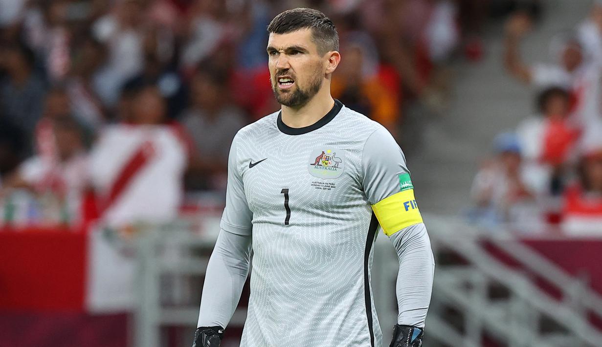 Mathew Ryan. Kiper Australia berusia 30 tahun yang baru bergabung dengan FC Copenhagen di awal musim 2022/2023 ini menjadi pemain aktif dengan penampilan terbanyak bagi Tim Socceroos dengan mengoleksi 75 caps sejak melakukan debut pada 5 Desember 2012. Piala Dunia 2022 Qatar akan menjadi Piala Dunia ketiganya, setelah selalu tampil dalam 2 edisi sebelumnya, 2014 dan 2018. Dari kedua edisi tersebut ia selalu tampil dalam 6 laga Timnas Australia yang selalu tersingkir di fase grup. (AFP/Karim Jaafar)
