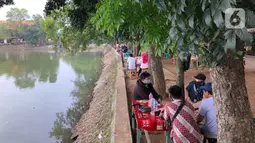 Pengunjung bersantai di Perkampungan Budaya Betawi Setu Babakan, Jakarta, Senin (22/6/2020). Danau buatan seluas 30 hektare tersebut kembali dibuka untuk umum setelah sebelumnya ditutup untuk mencegah penyebaran virus corona COVID-19. (Liputan6.com/Immanuel Antonius)